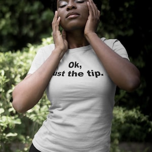 May include: A white t-shirt with black text that reads "Ok, just the tip."