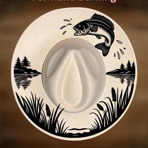 May include: A cream-colored fedora hat with a black graphic of a jumping fish, water droplets, and a lakeside scene. The hat has the text "For Hand Burning" and "CoolMoonDesigns".