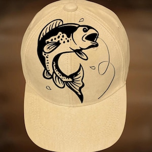 May include: A beige baseball cap featuring a black graphic of a fish with a fishing line. The text "For Hand Burning" is above the cap, and "CoolMoonDesigns" is below. The cap has a curved brim and a button on top.