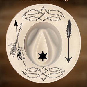 May include: Cream-colored cowboy hat with black decorative elements. The hat features arrows, a feather, and a sheriff's star. The text "For Hand Burning" and "CoolMoonDesigns" are also visible.