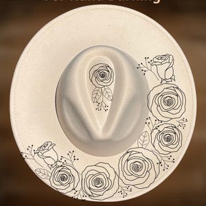 May include: Cream-colored fedora hat with a black floral design around the brim and on the crown. The text "For Hand Burning" and "CoolMoonDesigns" are printed on the hat.