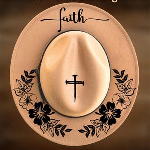 Puede incluir: Un sombrero fedora beige con un diseño de cruz y la palabra "faith" en escritura cursiva. El sombrero presenta detalles florales y de hojas negras alrededor del ala. También se ve el texto "For Hand Burning" y "CoolMoonDesigns".