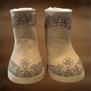 Puede incluir: Un par de botas de ante beige con un diseño floral. Las botas tienen forro y suelas de color crema. El texto "For Hand Burning" y "CoolMoonDesigns" se muestran en la imagen.