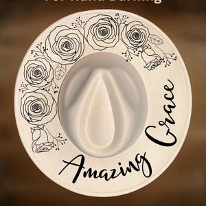 May include: A cream-coloured fedora hat featuring a black line-art illustration of roses and the text "Amazing Grace" printed on the brim. The top of the image includes the text "For Hand Burning" and the bottom includes "CoolMoonDesigns".