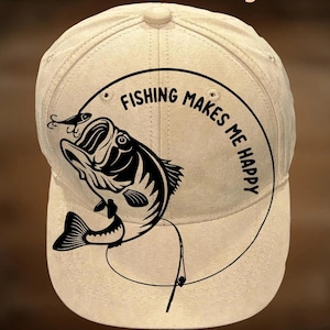 May include: A beige baseball cap with a black graphic of a fish and the words "FISHING MAKES ME HAPPY" in a circular design. The text "For Hand Burning" and "CoolMoonDesigns" are also visible.