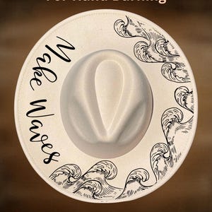 May include: A cream-coloured fedora hat with the words "Make Waves" in a script font. The hat has a wave design in black ink around the brim, with the text "For Hand Burning" and "CoolMoonDesigns".