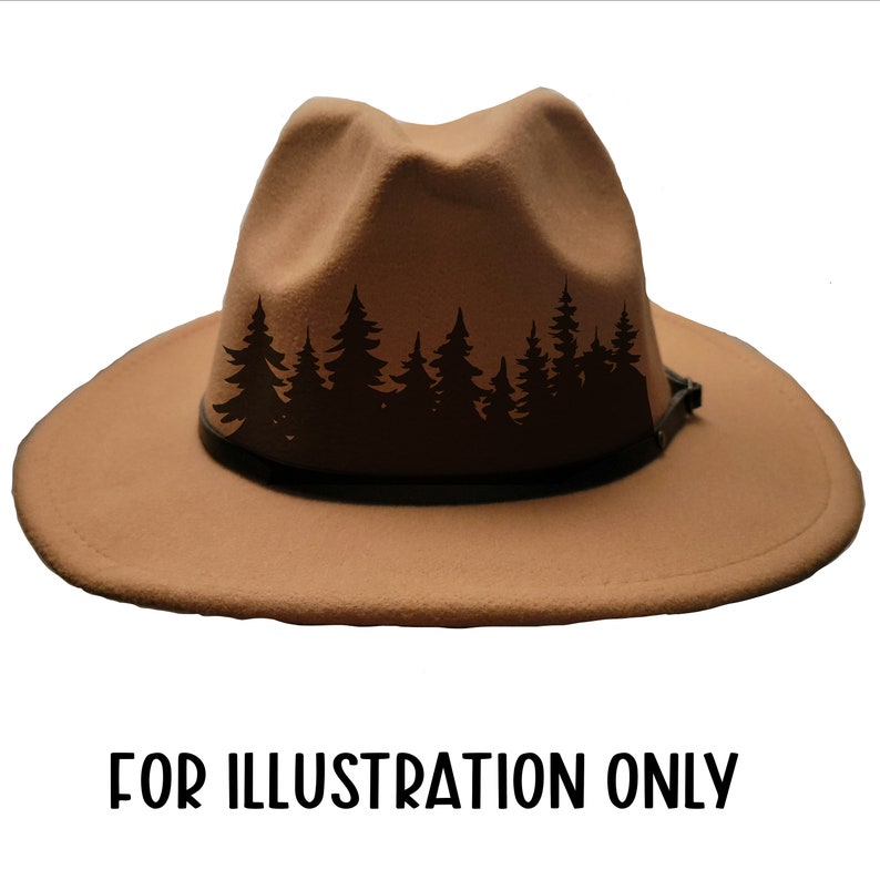 May include: A tan fedora-style hat with a black leather band and a forest silhouette design. The hat has a wide brim and a pinched crown. The text "FOR ILLUSTRATION ONLY" is at the bottom.