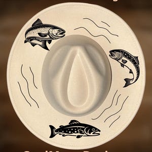 May include: Cream-colored fedora hat with three black fish illustrations and wavy lines. The text "For Hand Burning" and "CoolMoonDesigns" are printed on the hat.