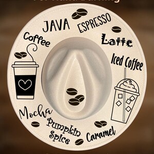 Puede incluir: Un sombrero fedora blanco con texto negro y gráficos temáticos de café. El sombrero presenta las palabras "Java", "Espresso", "Latte", "Iced Coffee", "Mocha", "Pumpkin Spice" y "Caramel". También está presente el texto "For Hand Burning" y "CoolMoonDesigns".