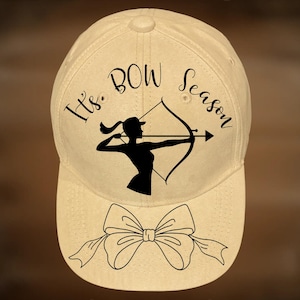 Puede incluir: Gorra de béisbol beige con el texto "It's BOW Season" y una silueta de una persona con arco y flecha. La gorra también presenta un gráfico de lazo en la visera. También se ve el texto "For Hand Burning" y "CoolMoonDesigns".