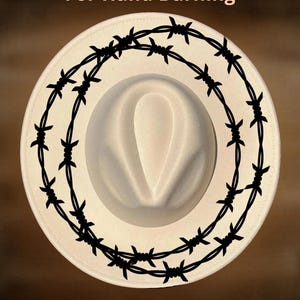 May include: A cream-colored fedora hat with a black barbed wire design around the brim. The text "For Hand Burning" is above the hat, and "CoolMoonDesigns" is below.