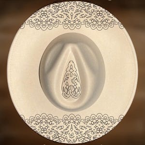Puede incluir: Un sombrero fedora de color crema con patrones de líneas negras que representan bordes de encaje y un diseño central en forma de lágrima. El texto "For Hand Burning" aparece arriba y "CoolMoonDesigns" está impreso en la parte inferior.