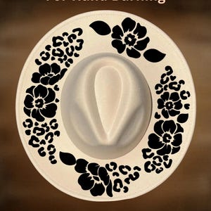 May include: A cream-colored fedora hat featuring a black printed design of flowers and leopard spots on the brim. The text "For Hand Burning" appears at the top and "CoolMoonDesigns" is printed at the bottom of the image.