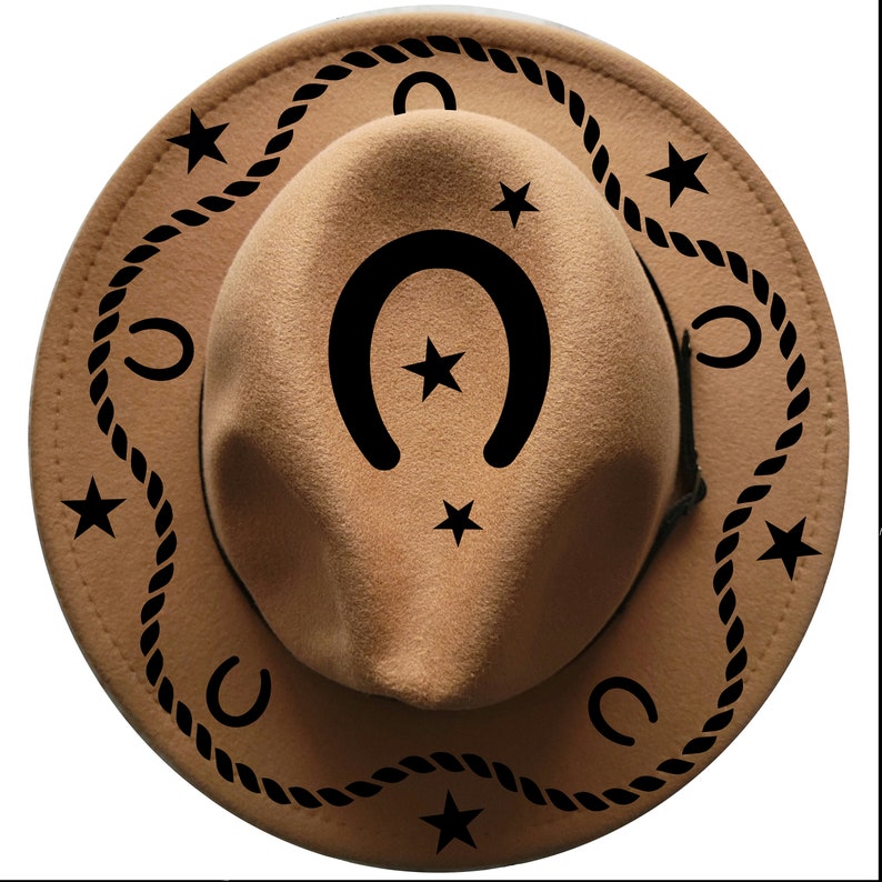 K&ouml;nnte beinhalten: Ein hellbrauner Cowboyhut mit schwarzen Seil-, Stern- und Hufeisenmustern. Der Hut hat eine runde Krone und eine breite Krempe. Die dekorativen Elemente sind gleichm&auml;&szlig;ig auf Krempe und Krone verteilt.