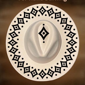 May include: A white fedora hat with a decorative black geometric pattern around the brim. The hat features the text "For Hand Burning" and "CoolMoonDesigns". The hat is a stylish accessory.