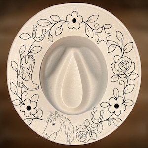 May include: A cream-colored fedora hat featuring a black line art design of a horse, cowboy boot, horseshoes, flowers, and a star. The text "For Hand Burning" appears at the top and "CoolMoonDesigns" at the bottom of the hat brim.