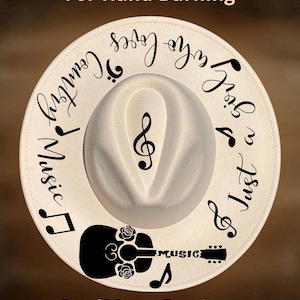 May include: White fedora hat with black musical notes, a guitar, and the words "Just a girl who loves country music." The hat also has the text "For Hand Burning" and "CoolMoonDesigns."