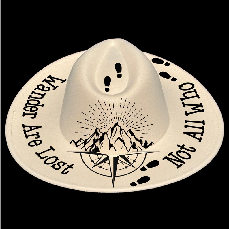 May include: Off-white hat with a wide brim, featuring black text and graphics. The text reads "Wander Are Lost Not All Who", encircling a mountain and compass design. Footprints and a mountain graphic are also present.