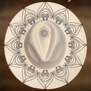 May include: A cream-coloured fedora hat featuring a black mandala pattern around the brim and a central design on the crown. The text reads "For Hand Burning" and "CoolMoonDesigns".