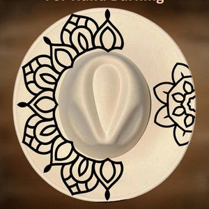 May include: A cream-colored fedora hat with a black mandala design on the brim. The text "For Hand Burning" and "CoolMoonDesigns" are printed on the hat. The hat has a rounded crown and a wide brim.