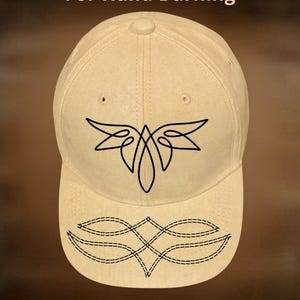 May include: A beige baseball cap with a black abstract design on the front. The cap features the text "For Hand Burning" above the design and "CoolMoonDesigns" below. The design is a stylized, symmetrical shape.
