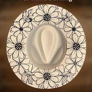 Può includere: Un cappello fedora con corona bianca e tesa larga. Il bordo è decorato con un motivo floreale in bianco e nero. Il testo "For Hand Burning" e "CoolMoonDesigns" è stampato sull'immagine.
