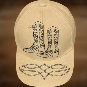 May include: A beige baseball cap with a black design of cowboy boots and decorative stitching on the brim. The text "For Hand Burning" and "CoolMoonDesigns" are printed on the cap.