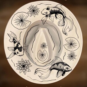 May include: Cream-colored fedora hat with black line art of koi fish, lily pads, and lotus flowers. The text "For Hand Burning" and "CoolMoonDesigns" are printed on the hat.