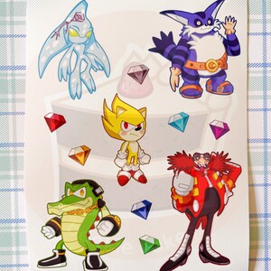May include: A sticker sheet featuring characters from the Sonic the Hedgehog video game series. The sheet includes Sonic, Knuckles, Tails, Shadow, and Eggman. The characters are depicted in a cartoon style and are surrounded by colorful gems.