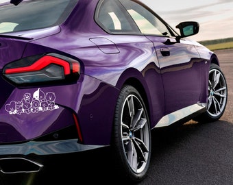 Puede incluir: Un coche morado con una pegatina de vinilo blanca de personajes de dibujos animados en el parachoques trasero.