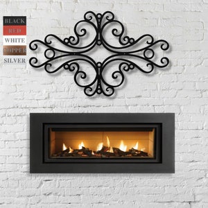 May include: A black metal wall decor with a decorative scroll design, mounted above a black fireplace with a glowing fire inside.