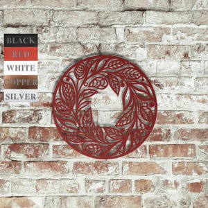 May include: A red metal wreath featuring a delicate floral design. The wreath is circular and has a cutout pattern of leaves and flowers.