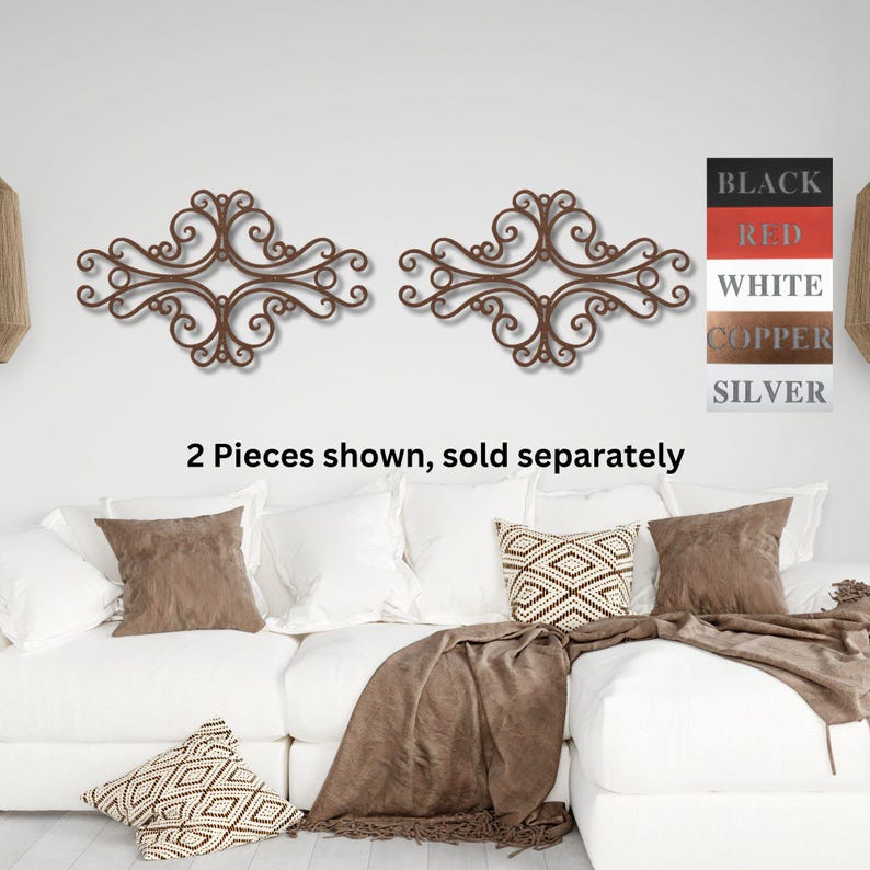 May include: Two decorative metal wall decor pieces in a scrolled design. The pieces are shown in a copper finish. The text "2 Pieces shown, sold separately" is below the decor.