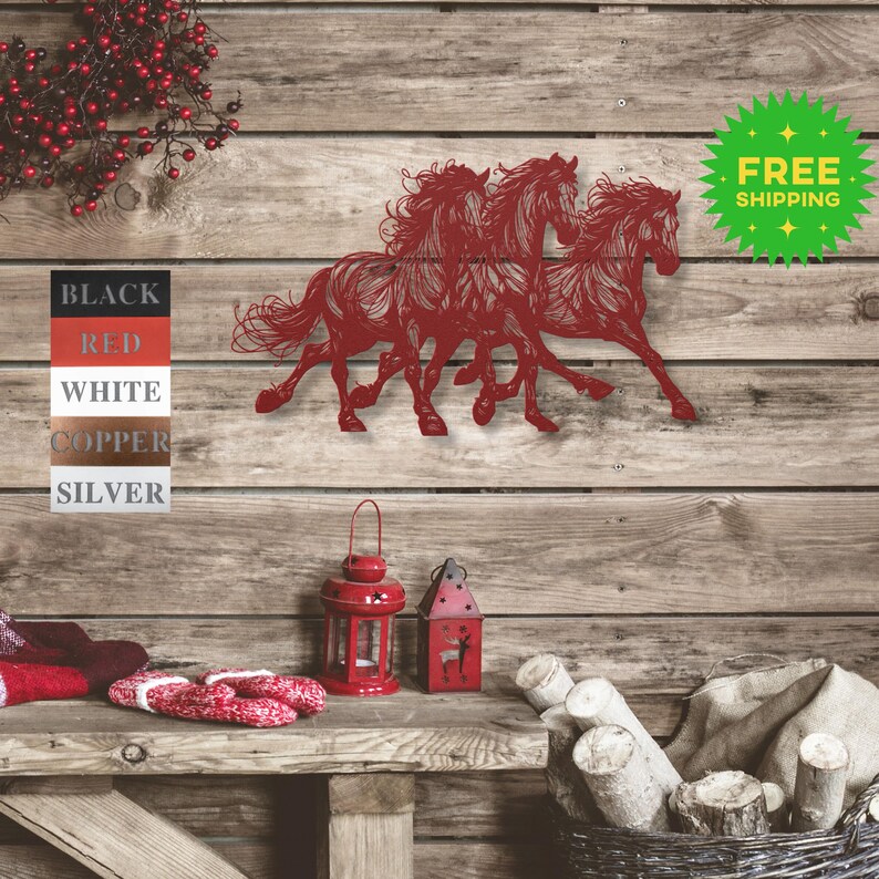 May include: Metal wall art featuring three horses running side by side. The horses are cut out of metal and painted red. The art is mounted on a wooden wall.
