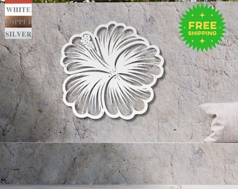 May include: White metal hibiscus flower wall decor with a detailed design. The flower is mounted on a gray concrete wall.