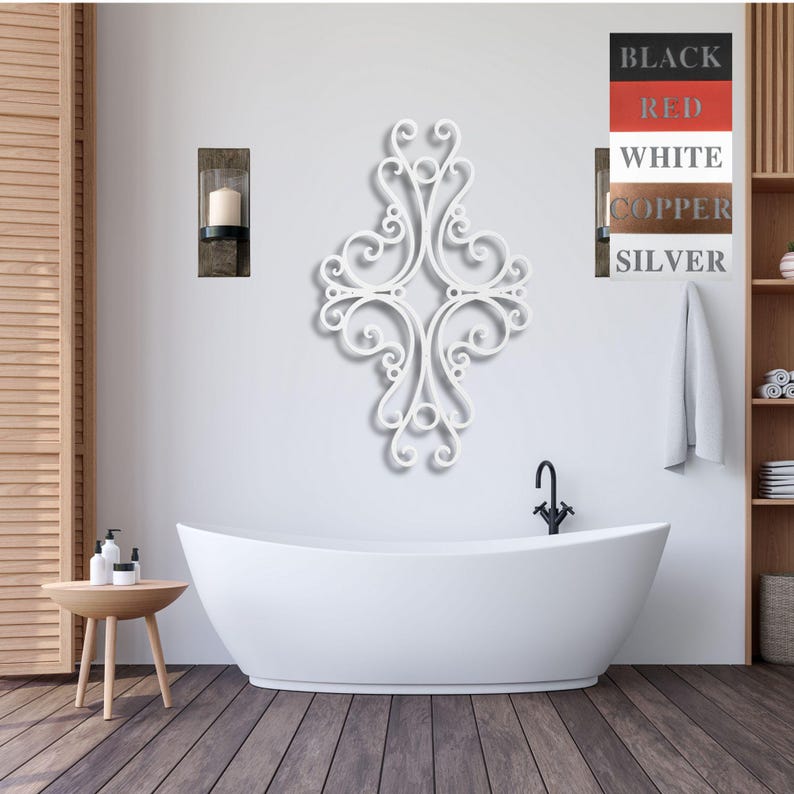 May include: White metal wall decor with a decorative scroll design. The decor is mounted on a white wall above a white bathtub.