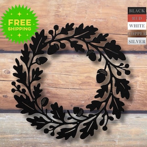 May include: Black metal wreath featuring oak leaves and acorns. The wreath is a circular design, perfect for seasonal decor. The image also includes a green starburst with the words "FREE SHIPPING".