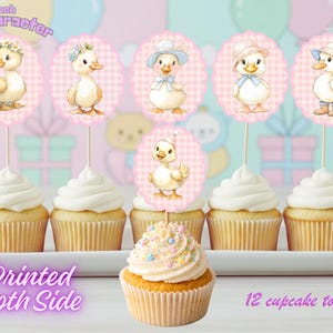 Puede incluir: Una docena de cupcakes con adornos de patitos. Los adornos, de aproximadamente 6,35 cm de diámetro, presentan ilustraciones de patos con diferentes atuendos. La imagen incluye el texto "Printed Both Side" y "12 cupcake topper".