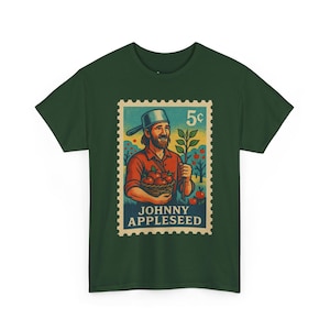 May include: Dark green t-shirt featuring a vintage-style postage stamp design. The stamp depicts a man with a beard, holding apples and a sapling, with the text "JOHNNY APPLESEED" and "5¢".