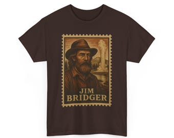 May include: A brown t-shirt featuring a vintage-style portrait of Jim Bridger, framed as a postage stamp. The portrait shows a man with a beard and hat, with a landscape background and the name "Jim Bridger" below.