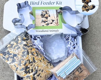 May include: A DIY bird feeder kit with woodland animal cookie cutters, birdseed, and twine. The kit includes a squirrel, owl, bird, and a heart-shaped cookie cutter. The kit also includes a bag of birdseed and twine for hanging the feeder.