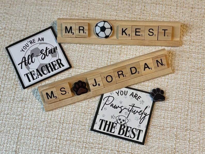 Handmade Scrabble tile name plate with custom names and decorative charms including apple, bus, bee, sports balls, and more. A fun, unique teacher desk accessory or coach gift, ideal for back-to-school or end-of-year presents.