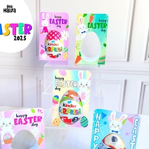 Puede incluir: Cuatro soportes de tarjetas de Pascua coloridos con ilustraciones de conejos y el texto "Feliz Día de Pascua". Cada soporte tiene un recorte para un huevo Kinder Sorpresa. Los soportes están en un estante de acrílico transparente.