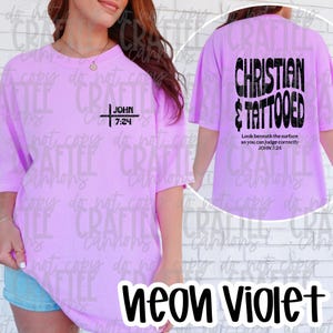 May include: Neon violet t-shirt with short sleeves. The front features a black cross design with the text "JOHN 7:24". The back of the shirt displays the words "CHRISTIAN & TATTOOED" and the text "Look beneath the surface so you can judge correctly JOHN 7:24".