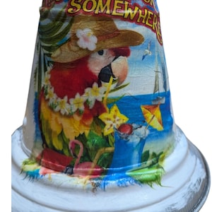 May include: White metal bell with a tropical design. The bell features a parrot wearing a hat and lei, with the text "It's 5 O'Clock Somewhere." The bell has a rope for hanging.
