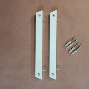 May include: Two white wall-mounted shelf brackets with four white plastic drywall anchors and screws.