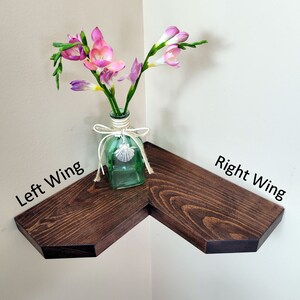 May include: A dark brown corner shelf with two angled shelves. The shelf is decorated with a vase of pink flowers.