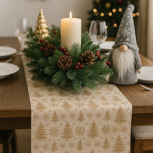 Puede incluir: Una mesa navideña festiva con un centro de mesa de velas encendidas rodeado de vegetación, piñas y bayas rojas. Se ve un camino de mesa beige con árboles de Navidad y copos de nieve dorados. Un gnomo decorativo está a la derecha.