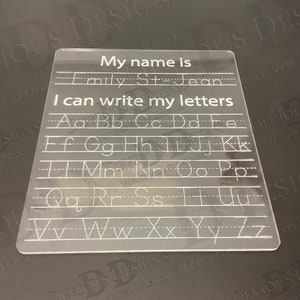 Könnte beinhalten: Ein transparentes Trockenlöschbrett aus Kunststoff mit dem Text "My name is" und Zeilen zum Schreiben eines Namens. Darunter steht der Text "I can write my letters" und Zeilen mit dem Alphabet in Kleinbuchstaben.