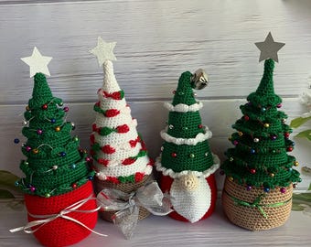 May include: Four handmade crochet Christmas trees in red, green, and white. Each tree has a star on top and is decorated with small beads. One tree has a gnome face and a silver bell. The trees are on a white wooden surface.